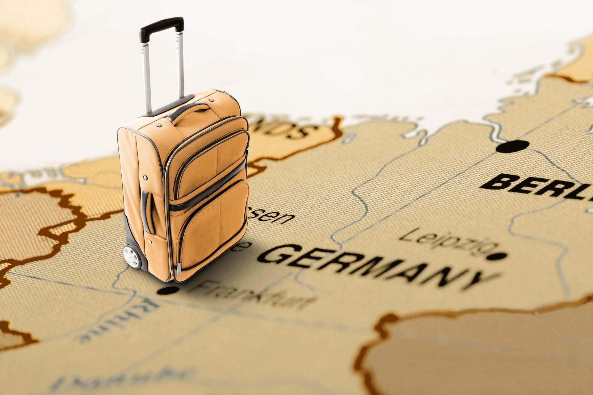 Destination Germany. Orange suitcase on the map.