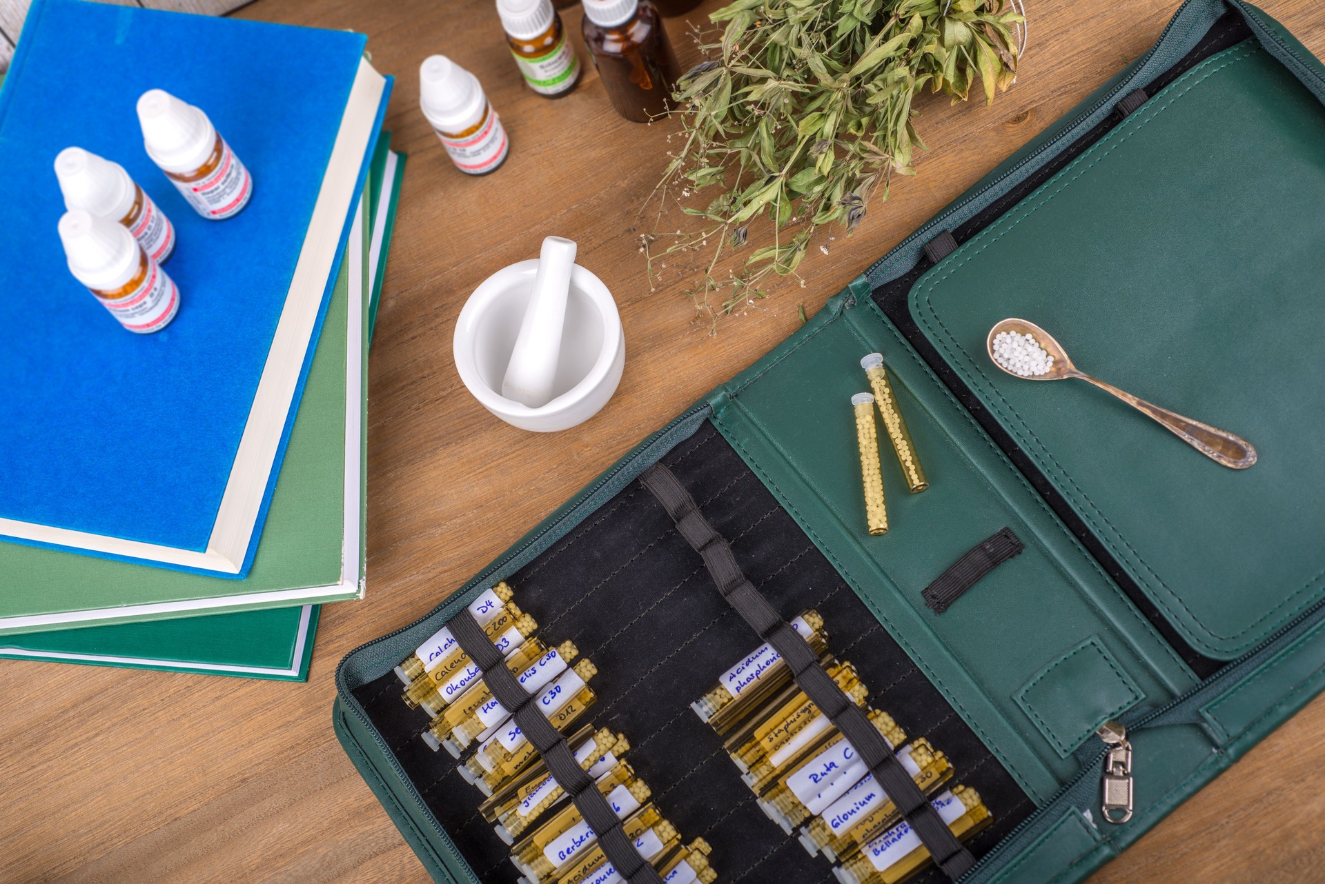 Homeopathy globules and vials on a table with books and folder